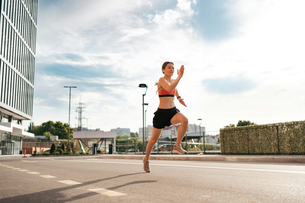 Female fitness model training outside in the city